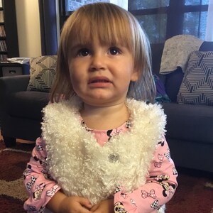Young girl’s knit top and furry vest
