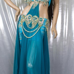 May include: A turquoise belly dancing costume with gold and jewel embellishments. The costume includes a bra top, a belt, and a flowing skirt.