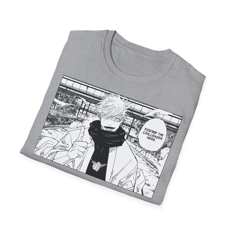 May include: A grey t-shirt with a black and white manga style illustration of a character with white hair and a scarf. The character is pointing with their index finger and the text "You're the challenger here." is in a speech bubble.