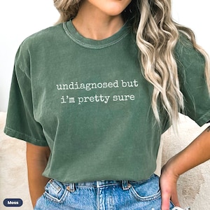 May include: A green t-shirt with the text "undiagnosed but i'm pretty sure" printed in white.
