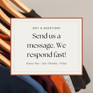 May include: A rectangular sign with a brown border and the text "GOT A QUESTION? Send us a message. We respond fast! Hours: 9am - 5pm | Monday - Friday." Clothes hang on wooden hangers in the background.