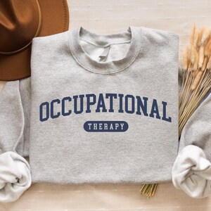 May include: Gray sweatshirt with the text "OCCUPATIONAL THERAPY" in navy blue letters.