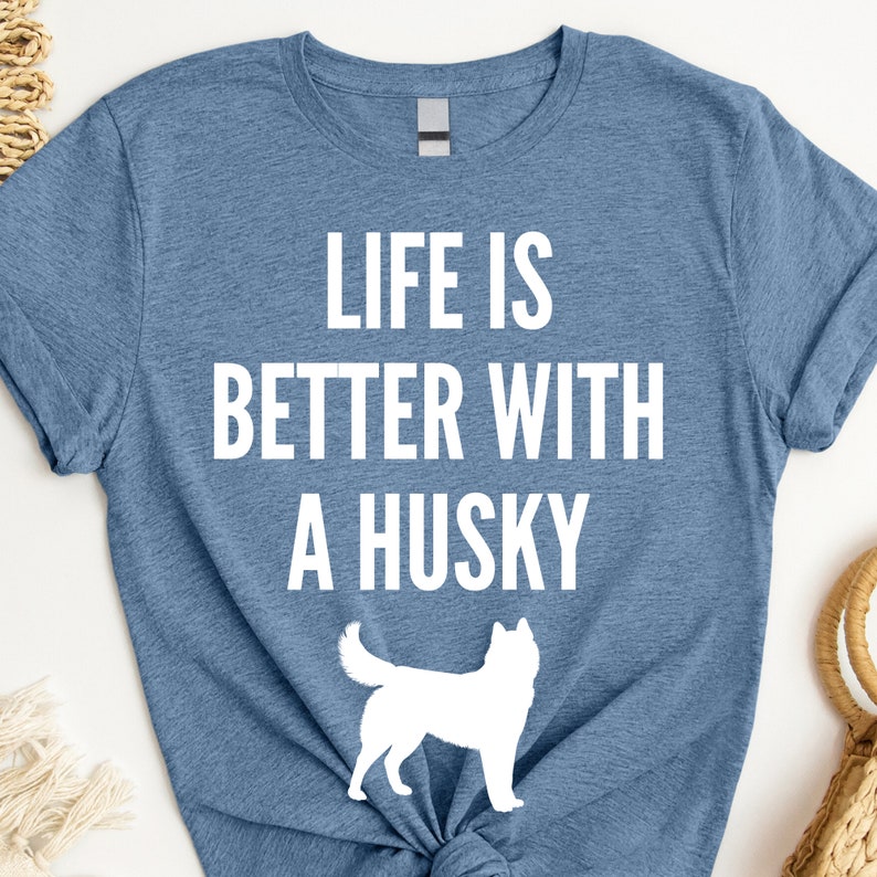 May include: A blue t-shirt with the text "Life is better with a husky" in white. A white silhouette of a husky is below the text.