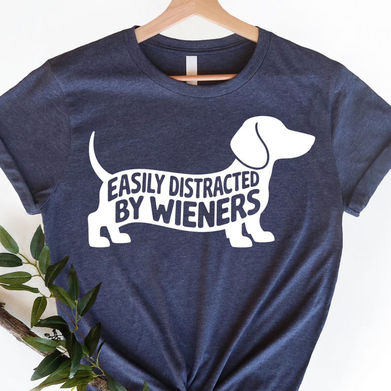 May include: A navy blue t-shirt with a white dachshund silhouette and the text "Easily Distracted By Wieners".