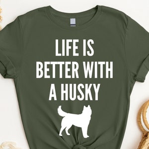 May include: A green t-shirt with the text "Life is better with a husky" in white. A white silhouette of a husky dog is below the text.