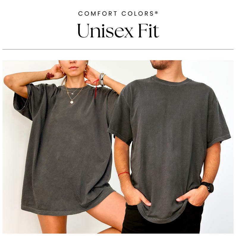 Pu&ograve; includere: Due persone indossano magliette oversize di colore grigio scuro con la scritta "COMFORT COLORS&reg; Unisex Fit" sovrapposta.