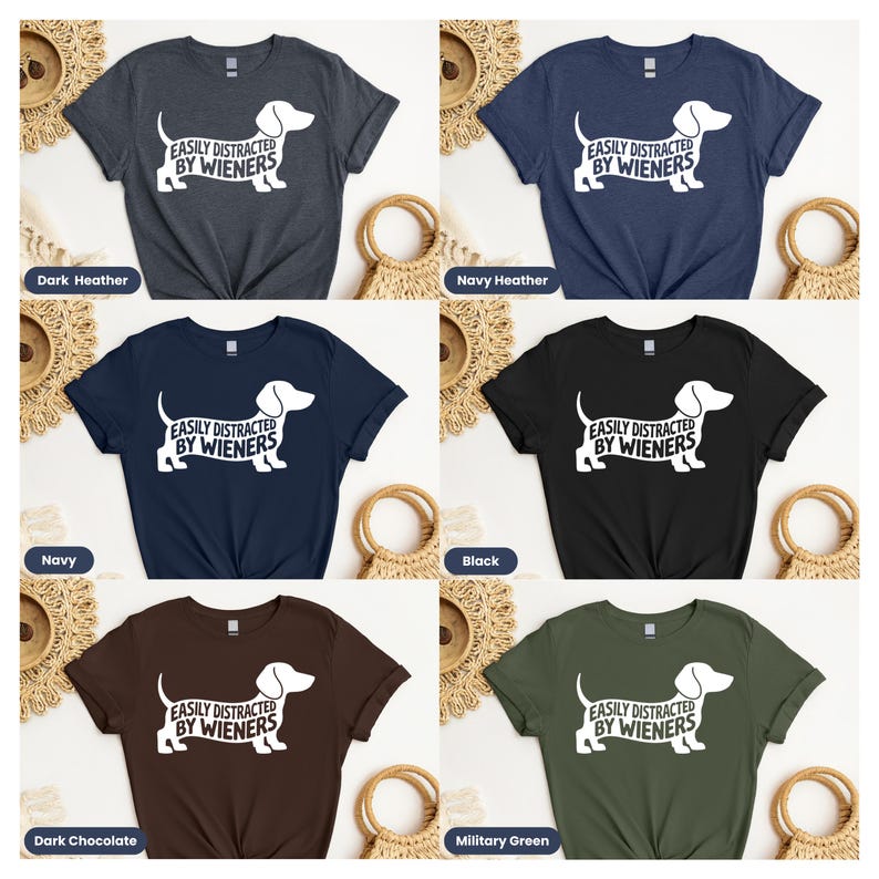 May include: Six different color t-shirts with a white dachshund silhouette and the text "EASILY DISTRACTED BY WIENERS". The colors are dark heather, navy heather, navy, black, dark chocolate, and military green.