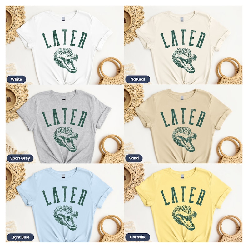 May include: Five different color t-shirts with the text "LATER" in a vintage font and a green alligator graphic. The colors are white, natural, sport grey, sand, and light blue.