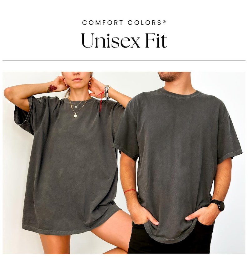 May include: Two people wearing a dark gray unisex t-shirt with a relaxed fit. The t-shirt has a vintage washed look. The text "COMFORT COLORS&reg; Unisex Fit" is displayed above the image.