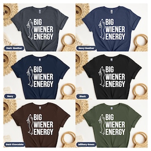 Pu&ograve; includere: Sei magliette di diversi colori con un contorno di bassotto bianco e il testo "BIG WIENER ENERGY". I colori sono grigio scuro melange, blu navy melange, blu navy, cioccolato scuro, nero e verde militare.