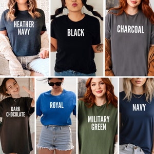 May include: A collection of t-shirts in various colors, each with a different color name printed in white. Colors include heather navy, black, charcoal, dark chocolate, royal, military green, and navy. The shirts are all short-sleeved and appear to be made of a soft material.