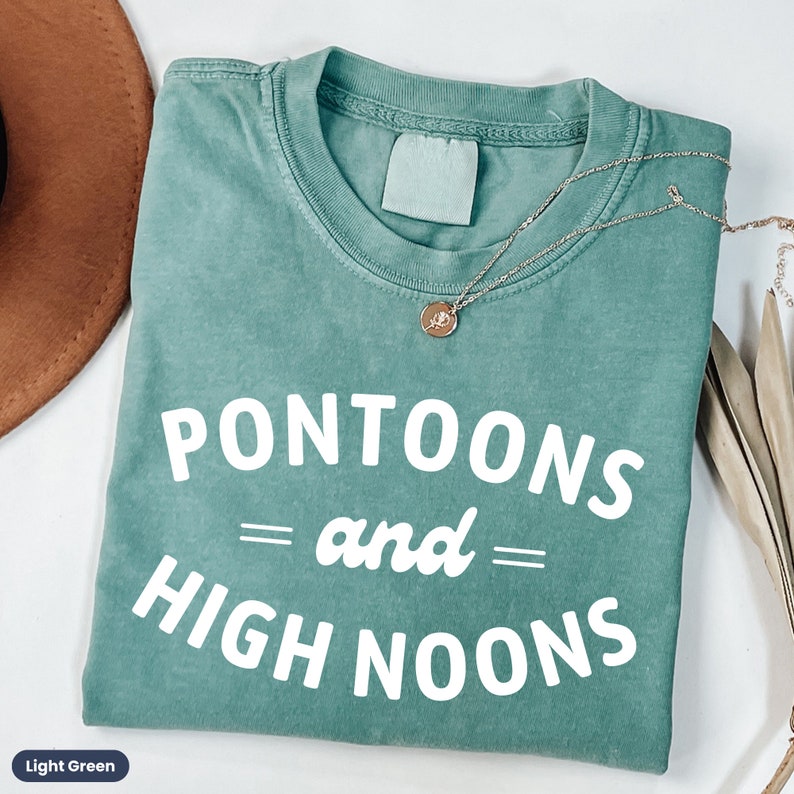 Pode incluir: Camiseta verde claro com o texto "Pontoons = and = High Noons" em branco.