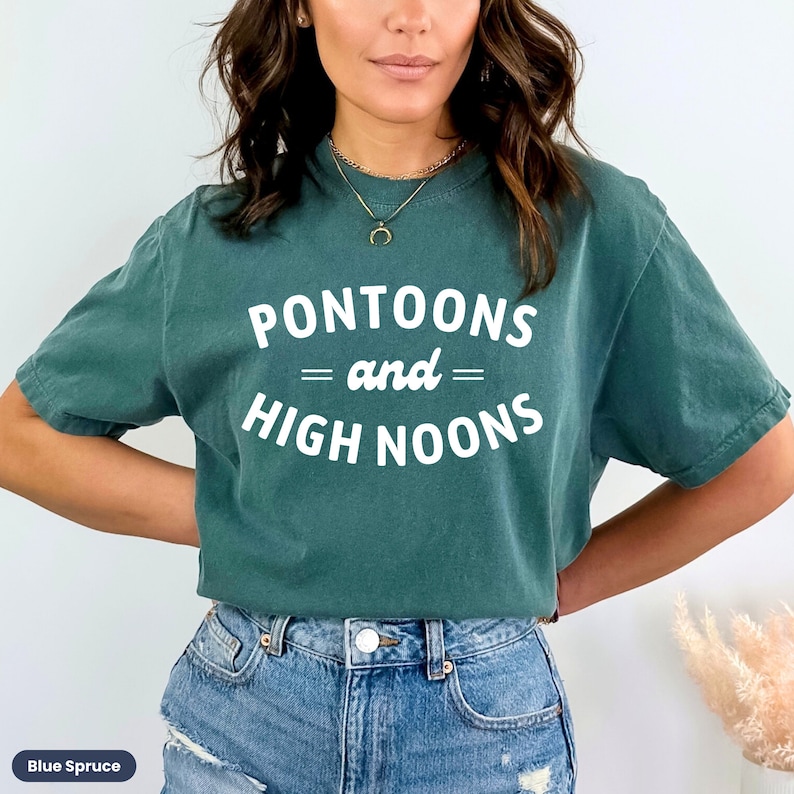 Pode incluir: Uma camiseta azul turquesa com texto branco que diz "Pontoons and High Noons".