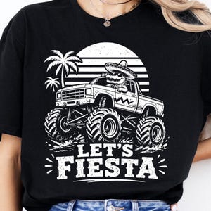 Peut inclure: T-shirt noir avec un motif blanc d'un monster truck conduit par un alligator portant un sombrero. Le motif comprend des palmiers, un soleil et le texte "LET'S FIESTA".