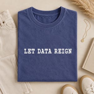 Könnte beinhalten: Ein marineblaues T-Shirt mit Rundhalsausschnitt und dem weißen Schriftzug LET DATA REIGN, der in einer fetten, serifenlosen Schrift mittig auf der Brust gedruckt ist. Das Kleidungsstück hat ein klassisches Kurzarmdesign mit geripptem Kragen.