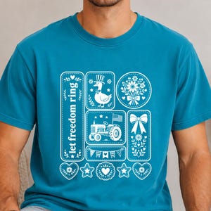 Peut inclure: Un t-shirt bleu sarcelle à col rond avec une impression graphique blanche. Le motif comprend un panneau vertical avec le texte 'let freedom ring', un canard portant un haut-de-forme, un tracteur avec un drapeau américain, un bouquet, un nœud et des guirlandes.