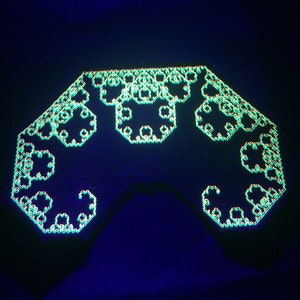 Puede incluir: Un patrón geométrico verde y negro, que se asemeja a un fractal, se muestra sobre un fondo oscuro. El patrón está formado por pequeñas formas repetitivas que crean un diseño complejo e intrincado.