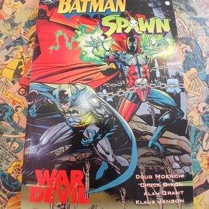 May include: A comic book cover featuring Batman and Spawn. The title "Batman Spawn" is at the top, with "War Devil" in large red letters. The artwork depicts the characters in action, with a dark, detailed style.