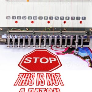 May include: A red stop sign with white lettering is being embroidered on a white fabric. The text "THIS IS NOT A PATCH" is below the stop sign.