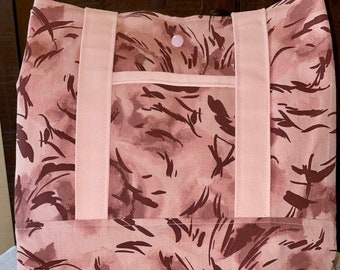 May include: A pink tote bag with brown abstract print and pink straps. The bag has a single button closure.