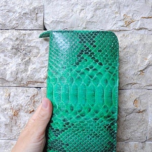 以下が含まれることがあります： 表面がテクスチャ加工された緑色のヘビ革財布