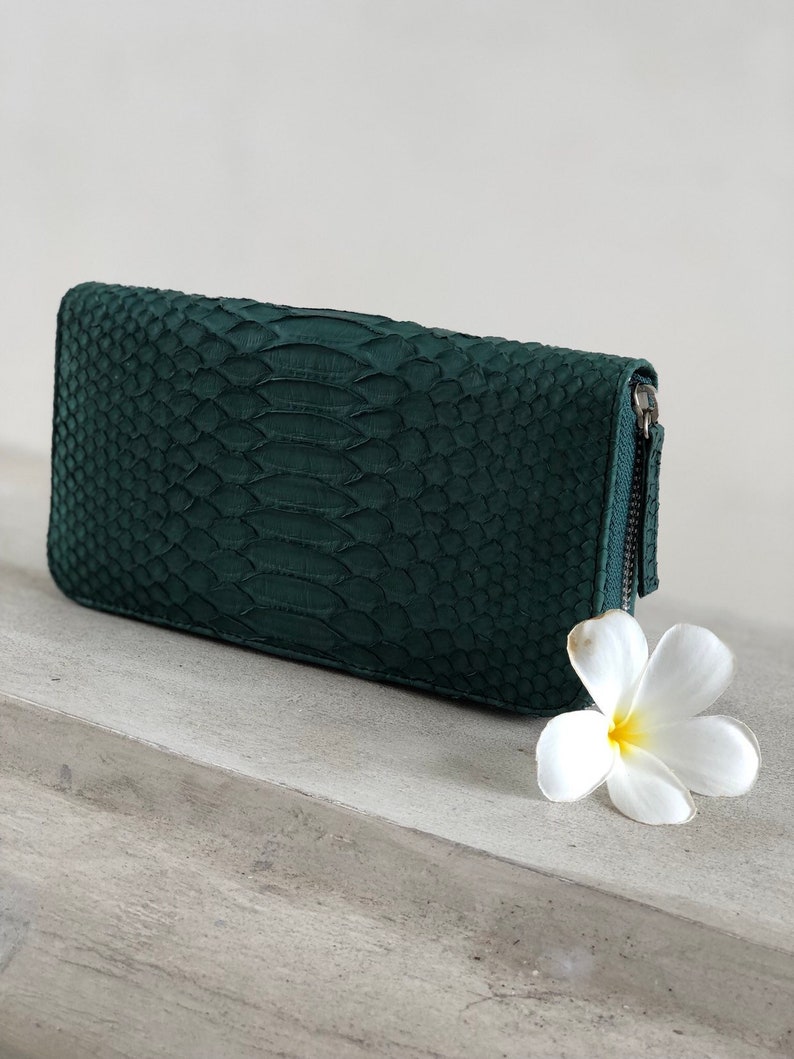 以下が含まれることがあります： ジッパー留めのダークグリーンのヘビ革財布