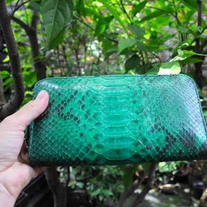以下が含まれることがあります： ジッパー付きの緑色のヘビ革財布