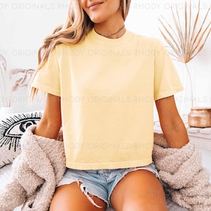 May include: A yellow cropped t-shirt with short sleeves and a crew neck. The t-shirt is made of a soft, comfortable fabric and is perfect for casual wear.