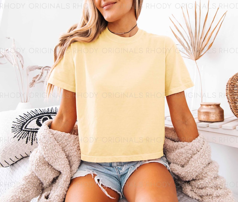 May include: A yellow cropped t-shirt with short sleeves and a crew neck. The t-shirt is made of a soft, comfortable fabric and is perfect for casual wear.