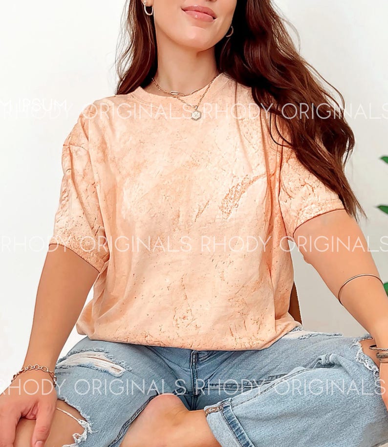 May include: A peach-coloured tie-dye t-shirt with a short sleeve and a relaxed fit. The shirt is made of a soft, comfortable material and has a subtle tie-dye pattern.