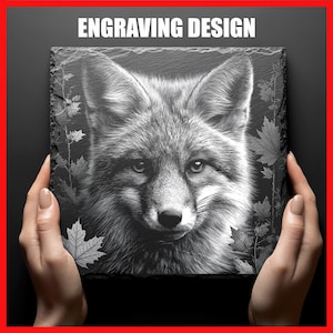 May include: A square slate with a black and white engraved fox design. The text "ENGRAVING DESIGN" is at the top. The fox portrait is detailed, with leaf patterns around the edges.