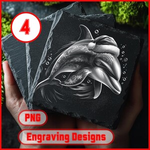 May include: A stack of three square black slate coasters. The top coaster features a detailed engraving of a dolphin wearing a Santa hat. The dolphin design is white and silver, with bubbles around it. The text "Engraving Designs" is at the bottom.
