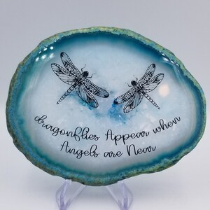 Puede incluir: Una rebanada de ágata azul con dos ilustraciones de libélulas negras y el texto "dragonflies Appear when Angels are Near".