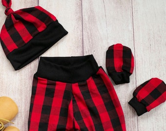May include: A red and black checked baby outfit set, including a hat, trousers and mittens. The outfit is laid out on a wooden surface. The text "Hartley Jax KIDS" is visible in the bottom right corner of the image.