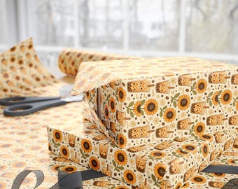 May include: Wrapping paper featuring a repeating pattern of yellow sunflowers and brown bubble tea cups with smiling faces on a cream background. The paper is shown covering rectangular boxes, with a roll and black ribbon visible nearby.
