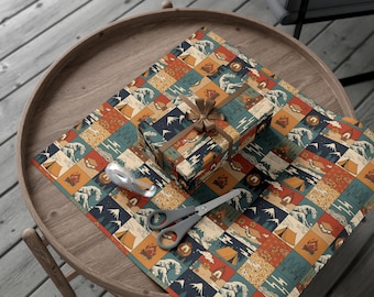May include: A wrapped gift box and wrapping paper with a camping-themed pattern featuring mountains, tents, and waves. The gift is tied with a brown ribbon. Scissors and a tape dispenser are on the wooden table.