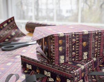May include: Wrapping paper with a dark purple background featuring a repeating pixel art pattern of books, mugs, and glasses. The text "ONE MORE CHAPTER" is printed in a repeating horizontal line across the paper, which covers two boxes.