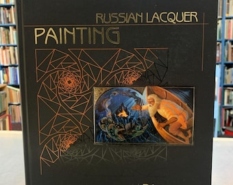 May include: A black book with gold lettering titled "Russian Lacquer Painting 21st Century". The cover features a geometric design and a painting of a man in a boat on a stormy sea.