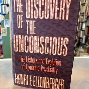 May include: A hardcover book titled "The Discovery of the Unconscious" by Henri F. Ellenberger. The book has a dark purple cover with white and red lettering. The title and author's name are prominently displayed.