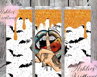 May include: A cylindrical tumbler with a metal straw, featuring a white background with black bat silhouettes and orange glitter drips at the top. The centre design displays a pair of lips with a spiderweb pattern and a hand making a shushing gesture.