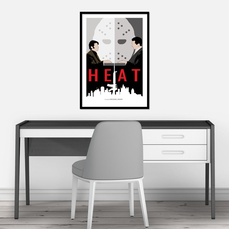May include: A minimalist poster design for the film "HEAT" featuring a black and white silhouette of two men facing each other with a hockey mask between them. The title "HEAT" is in red text and the film's director, Michael Mann, is credited at the bottom.
