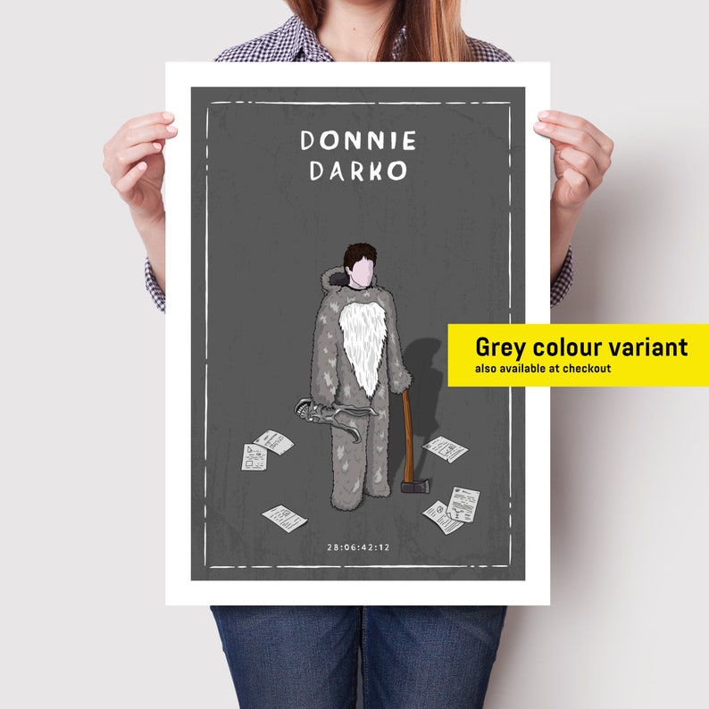 May include: A black and white illustration of a character from the movie Donnie Darko. The character is wearing a grey bunny costume and holding a tool and an axe. The text "Donnie Darko" and "28:06:42:12" are printed on the poster. The text "Grey colour variant also available at checkout" is printed on a yellow rectangle.
