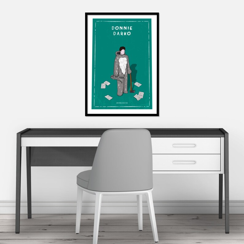 May include: A framed poster with a green background featuring a cartoon illustration of a person in a gray costume holding an axe. The text "DONNIE DARKO" is at the top of the poster.