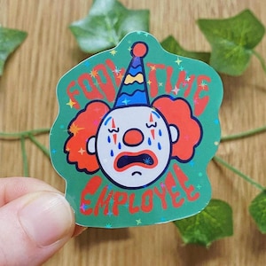 Könnte beinhalten: Ein Aufkleber mit einem weinenden Clown-Gesicht, rotem Haar und einer Partyhütchen. Der Text lautet "Full Time Employee". Der Hintergrund ist grün mit Sternen. Ein lustiges, skurriles Design.