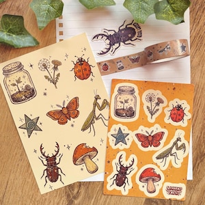 Peut inclure: Deux planches d'autocollants et un rouleau de ruban adhésif décoratif illustrés d'insectes, de champignons, de pissenlits, d'étoiles et d'un escargot dans un bocal. On y voit une coccinelle, un papillon, une mante religieuse et un lucane.