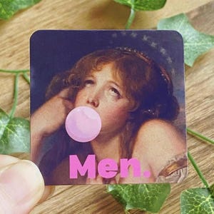 Könnte beinhalten: Quadratischer Aufkleber mit einem klassischen Gemälde einer Frau, die eine Kaugummiblase bläst. Die Blase ist rosa, und das Wort "Men." ist darunter in Rosa gedruckt. Der Hintergrund ist dunkelblau mit Sternen.