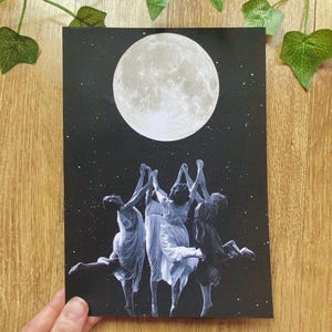 Könnte beinhalten: Ein rechteckiger Kunstdruck mit schwarzem Hintergrund, einer großen, detaillierten weißen Vollmondscheibe und einem Sternenhimmel. Vier Figuren in fließenden weißen Kleidern tanzen im Kreis und strecken ihre Arme zum Mond hinauf.