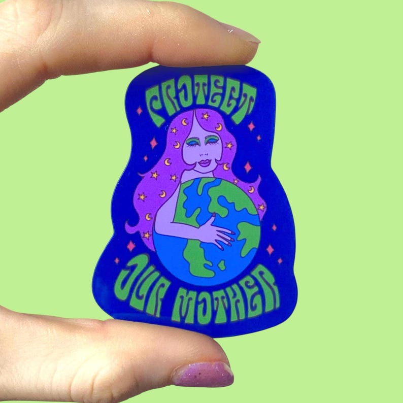 May include: A blue sticker with the words "PROTECT OUR MOTHER" in green. The sticker features a woman with purple hair embracing a blue and green globe, with stars and crescent moons.