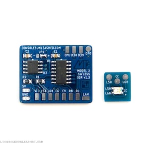 May include: A blue circuit board with the text "CONSOLESUNLEASHED.COM" and "MODEL 2 SW'LESS IGR v1.3" printed on it. The board has several components, including a chip labeled "CPU B38 839 DFO".