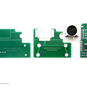 May include: Three green circuit boards with gold-plated connectors and text that reads "SM32 AV MOUNT v1.3 09/18/2022" and "SM32 AV BRACE v1.4 09/18/2022".